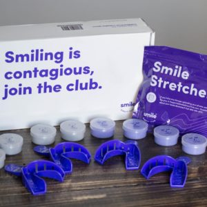 SmileDirectClub impression kit box, trays, putty containers, and smile stretcher